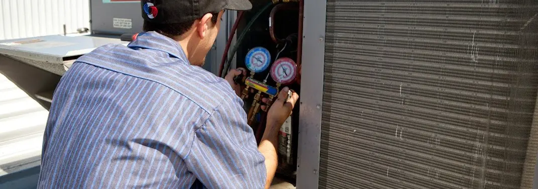 HVAC technician servicing a condenser unit in San Fernando